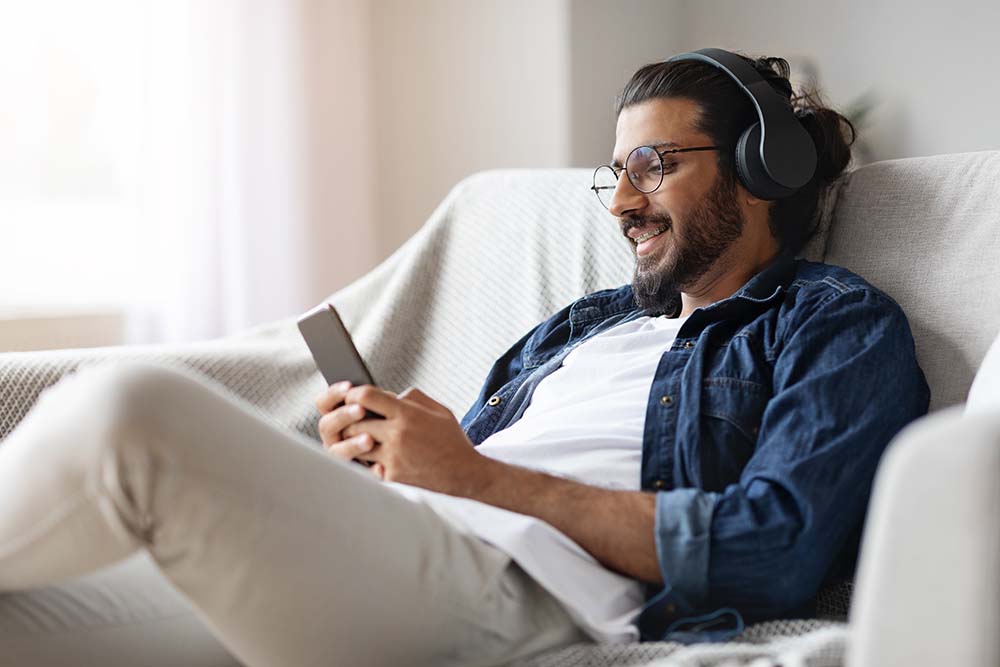 Man on couch watching podcast