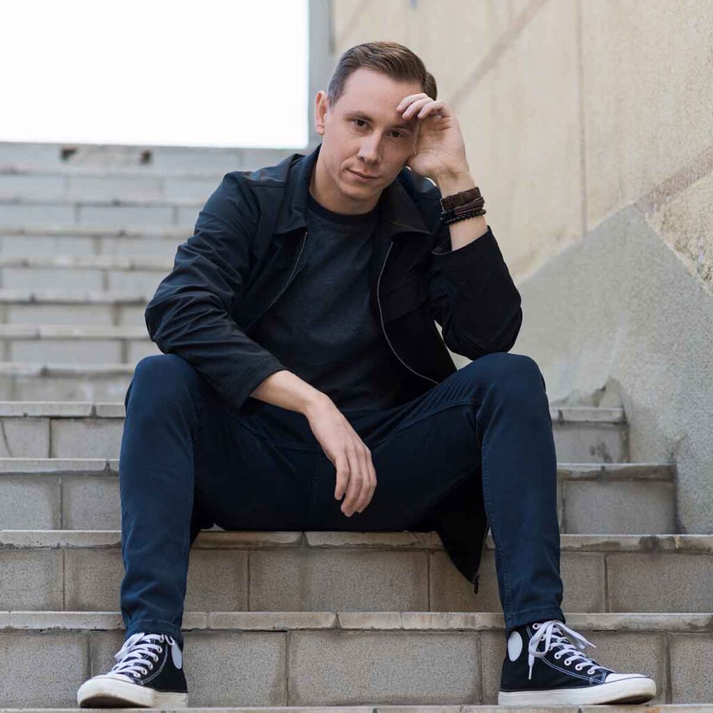 Young man sitting on steps outdoors