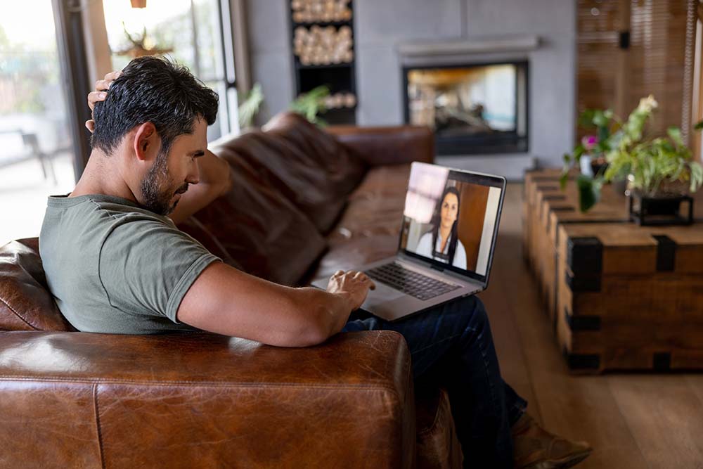 Young man in apartment on virtual therapy session