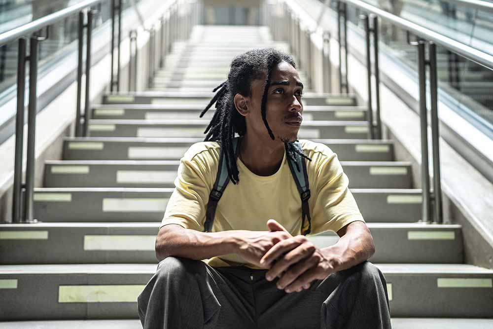 Young man sitting on steps outdoors