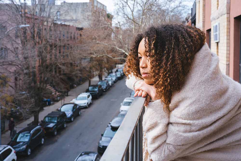 Young woman on balcony of apartment building